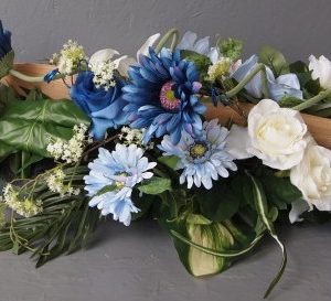 Pompes Funèbres Grosso : Dessus cerceuil coque bois fleurs diverses 110cm(longueur)x37cm(largeur)x21cm(hauteur) bleu