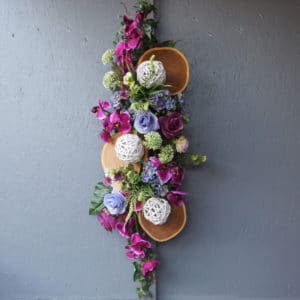 Pompes Funèbres Grosso : Raquette fleurs diverses rondin bois 94cm(longueur)x34cm(largeur)x24cm(hauteur) parme